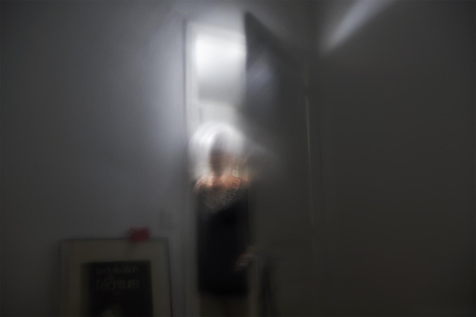 Marc est dans l'obscurité et regarde Michelle près de la porte